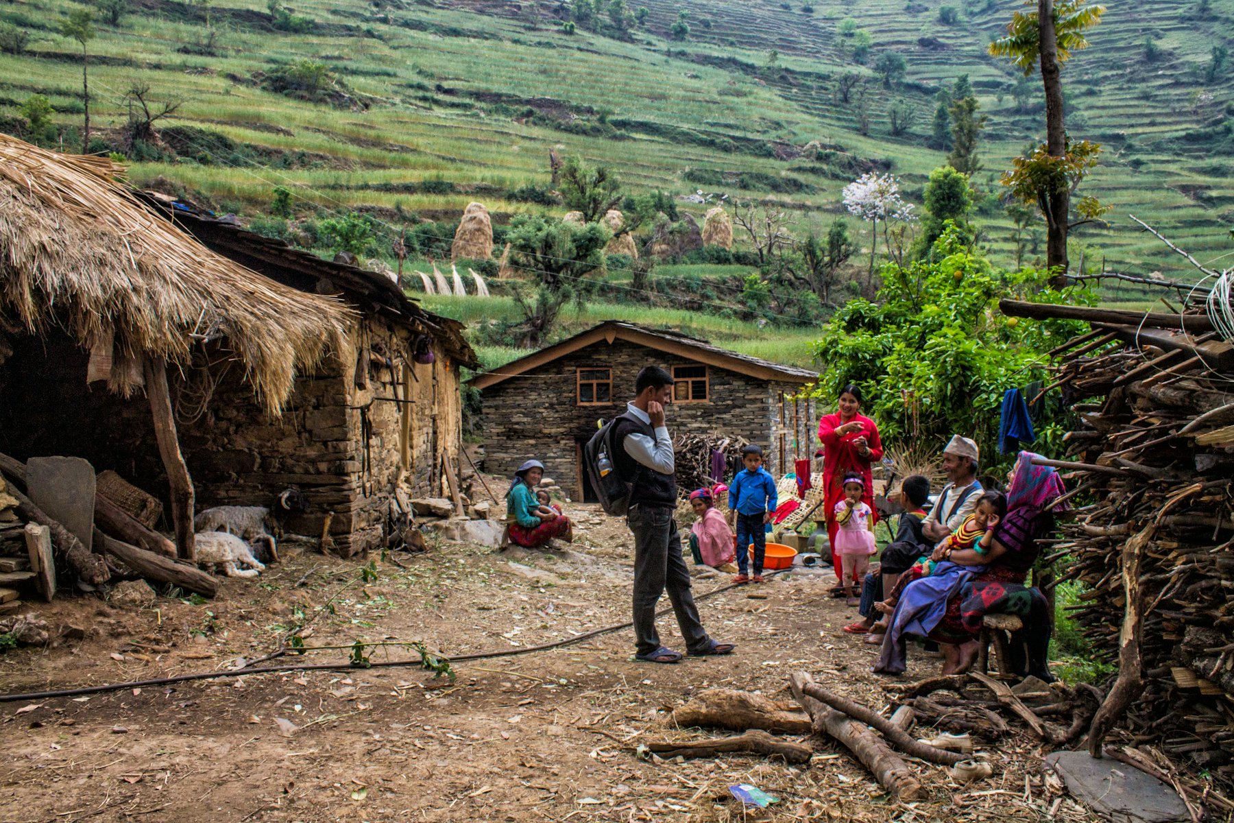 Families gathered outside stone houses in a hillside village