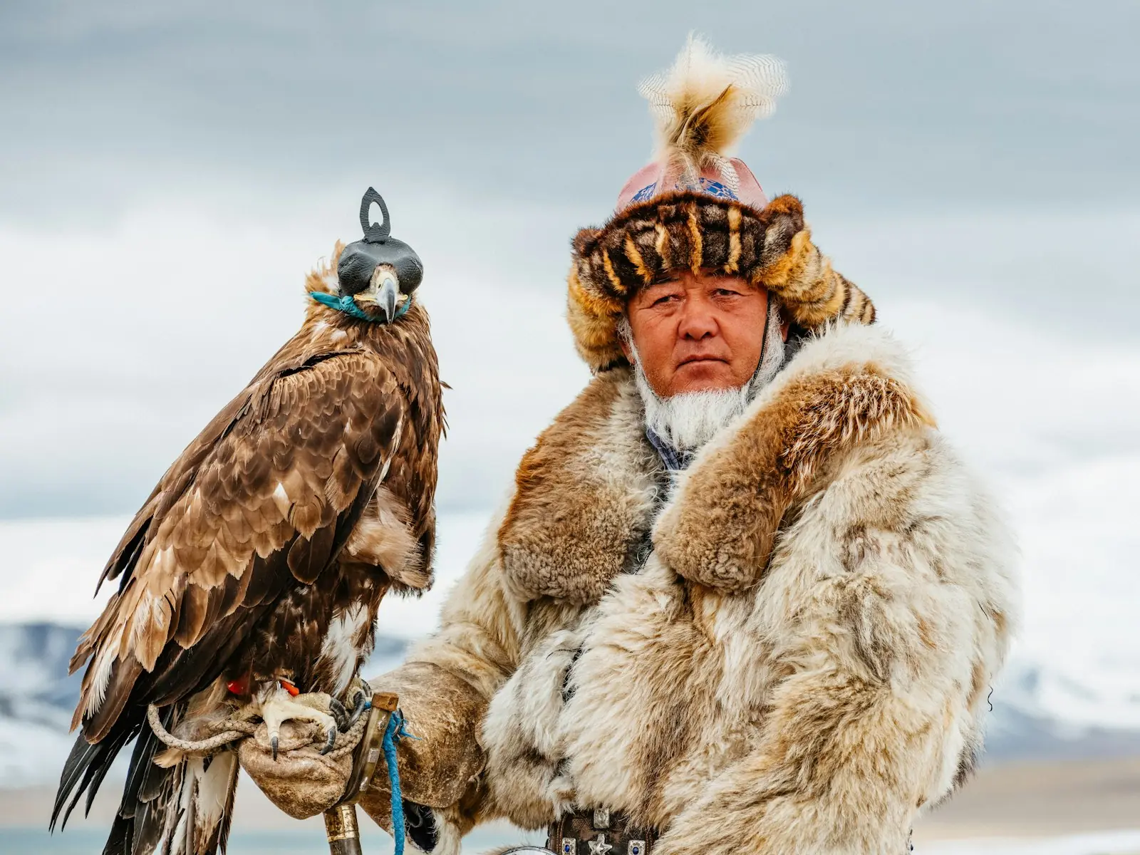 Un cazador kazajo con abrigo de piel y su águila